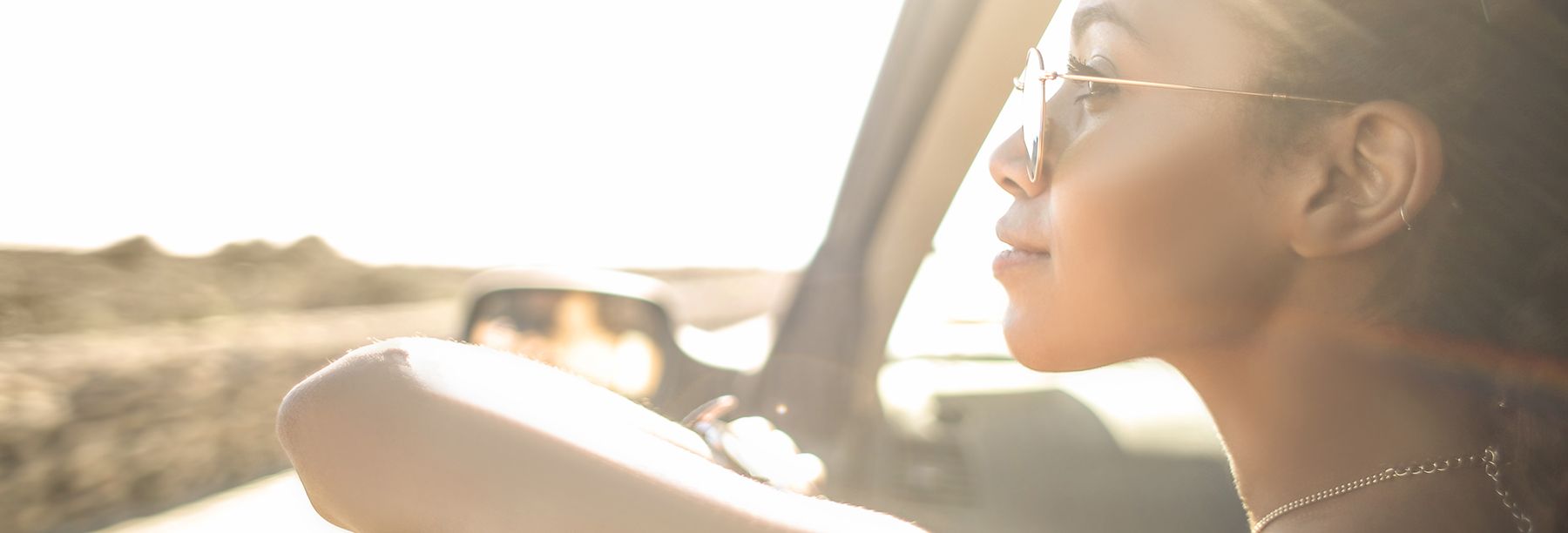 Business woman sitting in front of car