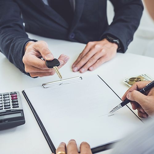 Calculating a car purchase  stack of coins, red car, pen, sheet, and calculator on desk